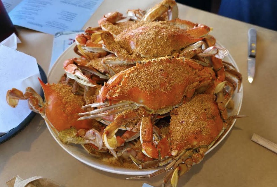 Heaping pile of Old Bay seasoned Maryland blue crabs on brown butcher paper